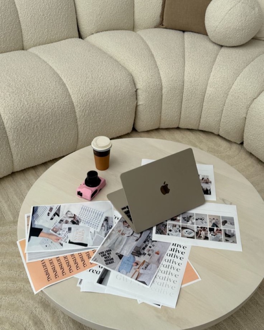 Printed campaign layouts and concepts spread across a table